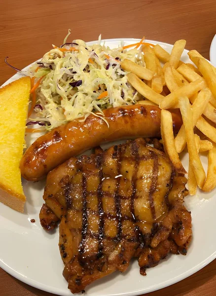 Stock image grilled pork steak with french fries and potato wedges