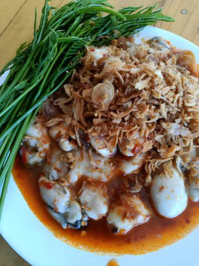 Sarımsaklı istiridye ve beyaz tabakta sebze.