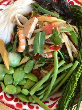 Tayland yemeği papaya salatası lahana bahçeli uzun fasulye beyaz tabak, papaya salatası yengeç ve mayalanmış balık.