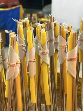 Sarı mum ve tütsü çubukları yığınına yakın.