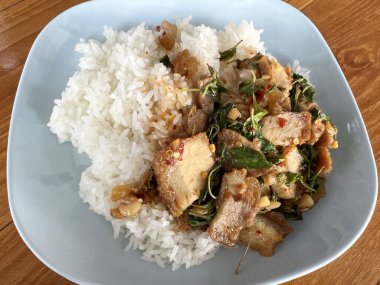 Kızarmış domuz eti ve fesleğenli pilav ve sebze tabağı.