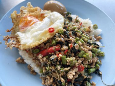 Masada kızarmış domuz ve fesleğen var.