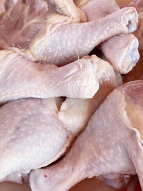 Süpermarketin tezgahında çiğ tavuk budu var.