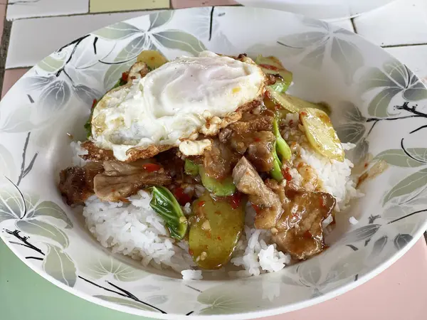 Pirinçli sahanda yumurta ve ahşap masada kızarmış domuz eti.