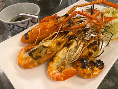 Beyaz tabakta ızgara karides.