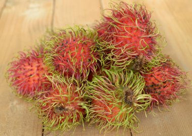 ahşap arka planda rambutan meyvesi
