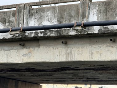 Beton köprü duvarındaki eski metal boru.