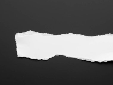 Siyah arkaplanda beyaz kağıt yırtıldı.