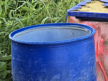 Bahçe için eski mavi plastik fıçı.