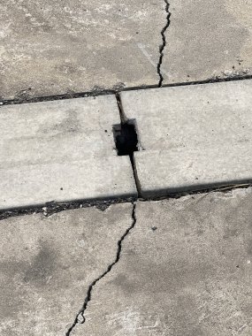 Beton zemin ve yolda kırık bir delik..