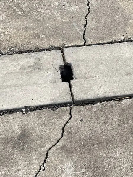 Beton zemin ve yolda kırık bir delik..