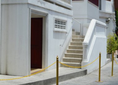 Duvarın önünde merdiveni olan beyaz bir kapı.