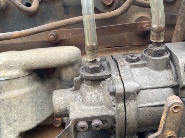 Büyük metal bir borusu olan paslı eski bir motor.