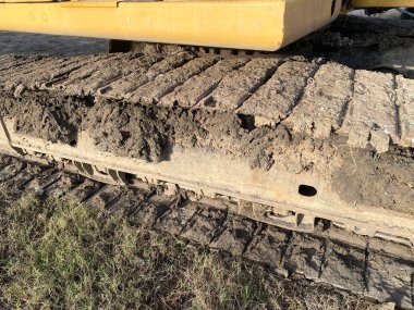 Yolun kumlarında büyük bir kazıcı.