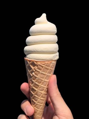 Beyaz çikolatalı dondurma külahını tutan el..