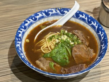 Sebzeli erişte çorbası ve ahşap kasede baharat.