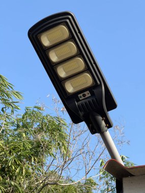 Beyaz arka planı ve mavi gökyüzü olan elektrik lambası.