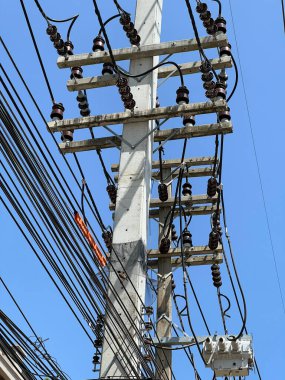 Akşamları elektrik kabloları ve kabloları olan yüksek voltajlı elektrik direği..