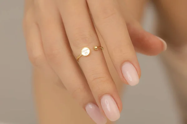 Jewelry on the girl\'s hand with soft nail polish. Extraordinary Woman jewelry concept. Jewelry image for e-commerce, online sale, social media.