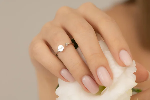 Jewelry on the girl's hand with soft nail polish. Extraordinary Woman jewelry concept. Jewelry image for e-commerce, online sale, social media.