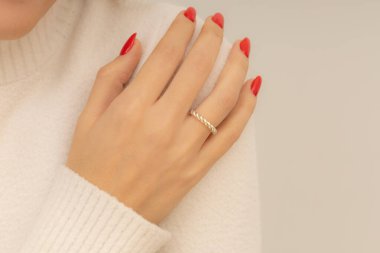 Kırmızı tırnaklı seksi bayanın elinde yüzük. Ürün imajı e-ticarette, sosyal medyada ve çevrimiçi satışlarda kullanılabilir. Mücevher fotoğrafında kadın mücevher konsepti.