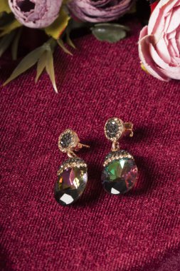 Kırmızı arka plan ve çiçekli mücevher görsel konsepti. E- ticaret, sosyal medya ve satışlar için kadın mücevherlerinin fotoğrafı.