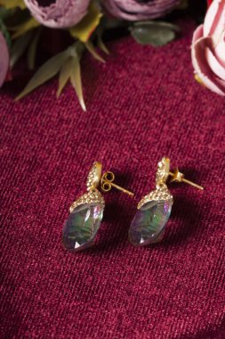 Kırmızı arka plan ve çiçekli mücevher görsel konsepti. E- ticaret, sosyal medya ve satışlar için kadın mücevherlerinin fotoğrafı.