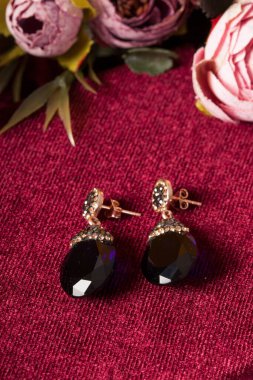 Kırmızı arka plan ve çiçekli mücevher görsel konsepti. E- ticaret, sosyal medya ve satışlar için kadın mücevherlerinin fotoğrafı.