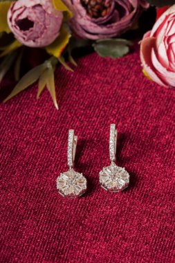 Kırmızı arka plan ve çiçekli mücevher görsel konsepti. E- ticaret, sosyal medya ve satışlar için kadın mücevherlerinin fotoğrafı.