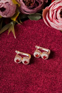 Kırmızı arka plan ve çiçekli mücevher görsel konsepti. E- ticaret, sosyal medya ve satışlar için kadın mücevherlerinin fotoğrafı.