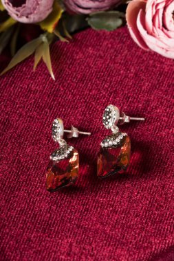 Kırmızı arka plan ve çiçekli mücevher görsel konsepti. E- ticaret, sosyal medya ve satışlar için kadın mücevherlerinin fotoğrafı.