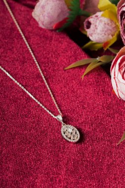 Kırmızı arka plan ve çiçekli mücevher görsel konsepti. E- ticaret, sosyal medya ve satışlar için kadın mücevherlerinin fotoğrafı.