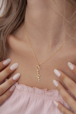 Bakımlı bayan renkli elbisesiyle özel mücevherlerini sergiliyor. E-ticaret satışları için modellenmiş mücevher fotoğrafı.