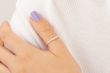 Kadın mücevher konsepti. Renkli ojeli bir kadın yüzü. Gümüş ve altın mücevherler.