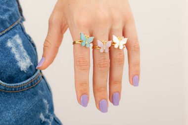 Kadın mücevher konsepti. Renkli ojeli bir kadın yüzü. Gümüş ve altın mücevherler.