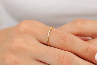 İyi bakımlı tırnakları ve mücevher konsepti olan bir imaj. Kadın model parmağında altın zarif bir yüzük gösteriyor. E-ticaret, sosyal medya ve tüm platformlar için mücevher fotoğrafçılığı.