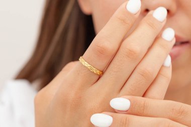 İyi bakımlı tırnakları ve mücevher konsepti olan bir imaj. Kadın model parmağında altın zarif bir yüzük gösteriyor. E-ticaret, sosyal medya ve tüm platformlar için mücevher fotoğrafçılığı.