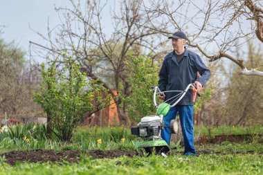 Çiftçi adam ekiciyle toprağı sürüyor toprağı ekime hazırlıyor..