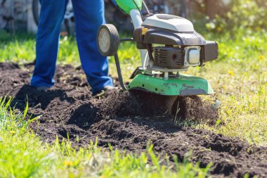 Çiftçi adam ekiciyle toprağı sürüyor toprağı ekime hazırlıyor..