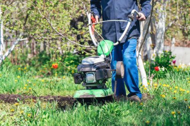 Çiftçi adam ekiciyle toprağı sürüyor toprağı ekime hazırlıyor..