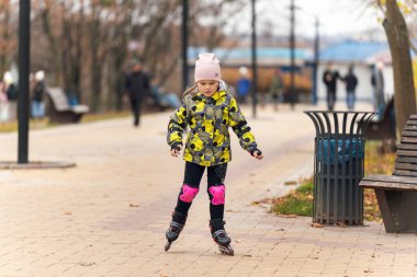 Tatlı küçük kız paten kaymayı öğreniyor..