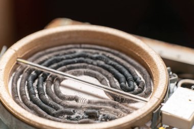 Yanmış ısıtma elementleri, kablolar ve kablolarla parçalanmış elektrik ocağı.