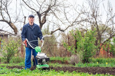 Çiftçi adam ekiciyle toprağı sürüyor toprağı ekime hazırlıyor..