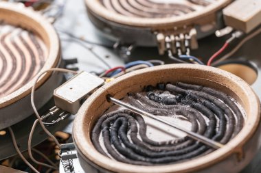 Yanmış ısıtma elementleri, kablolar ve kablolarla parçalanmış elektrik ocağı.