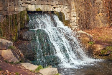 Sonbahar parkındaki eski bir binada küçük bir şelale..