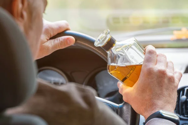 Chauffeur Zit Achter Het Stuur Houdt Een Fles Alcoholische Drank Stockfoto