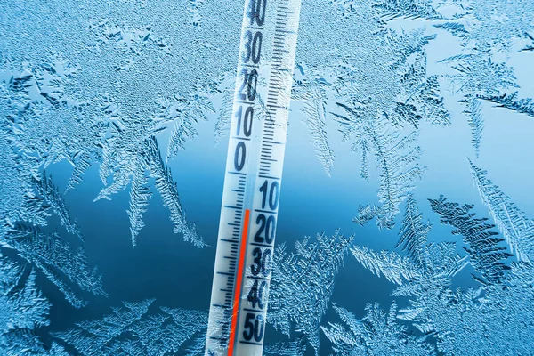Buz kalıplı soğuk kış penceresi ve eksi sıcaklık gösteren bir termometre..