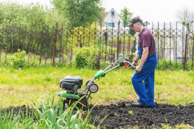 Çiftçi adam ekiciyle toprağı sürüyor toprağı ekime hazırlıyor..