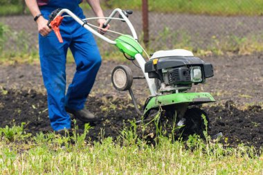 Çiftçi adam ekiciyle toprağı sürüyor toprağı ekime hazırlıyor..