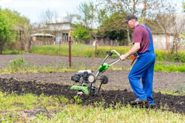 Çiftçi adam ekiciyle toprağı sürüyor toprağı ekime hazırlıyor..